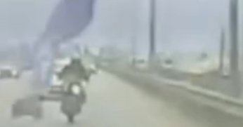 Köprüden sarkan reklam afişi motosikletliyi savurdu